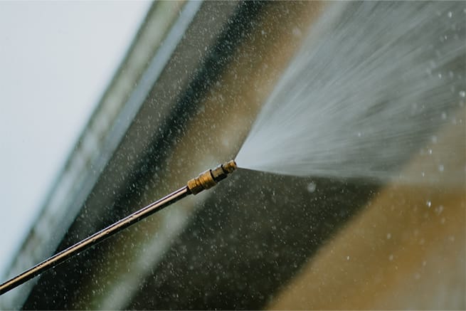 Elegant Styles Power Wash technician cleaning gutters on a residential home in Naples, Florida