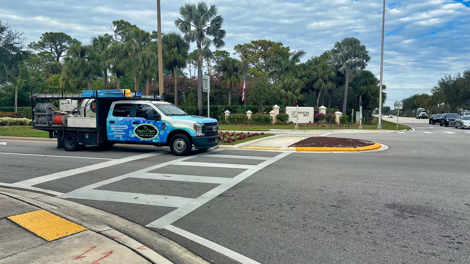 Elegant Styles Power Washing and Paver Sealing truck in front of Pelican Bay entrance in Naples, Florida.
